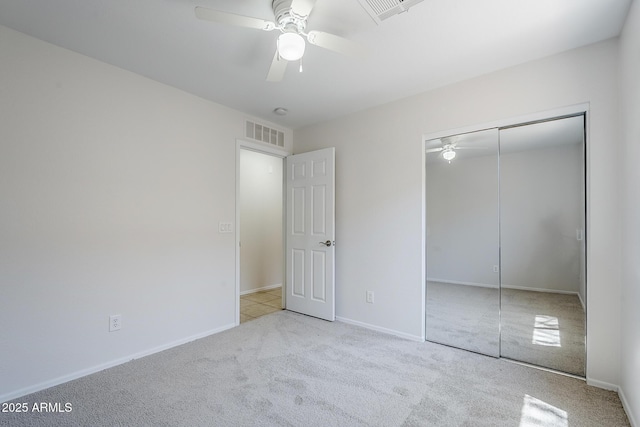 unfurnished bedroom featuring carpet, a ceiling fan, baseboards, visible vents, and a closet