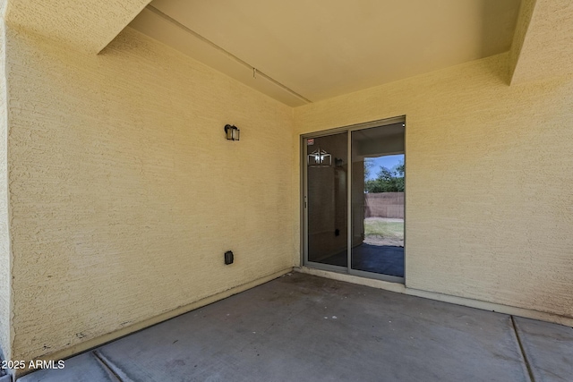 view of exterior entry featuring a patio area and stucco siding