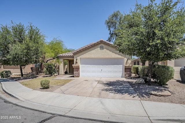 view of front of property featuring stucco siding, an attached garage, driveway, and a tile roof