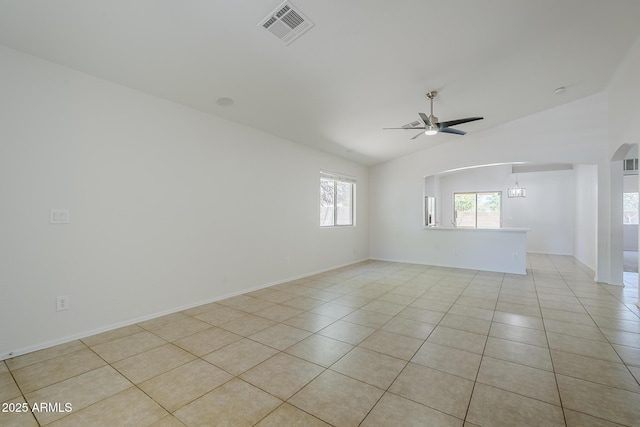 unfurnished room featuring ceiling fan, arched walkways, light tile patterned floors, vaulted ceiling, and visible vents