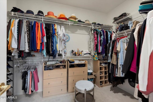 walk in closet featuring light carpet