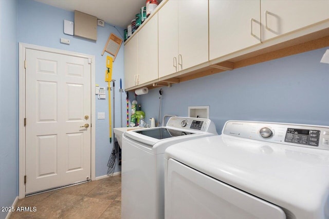 clothes washing area with separate washer and dryer and cabinets