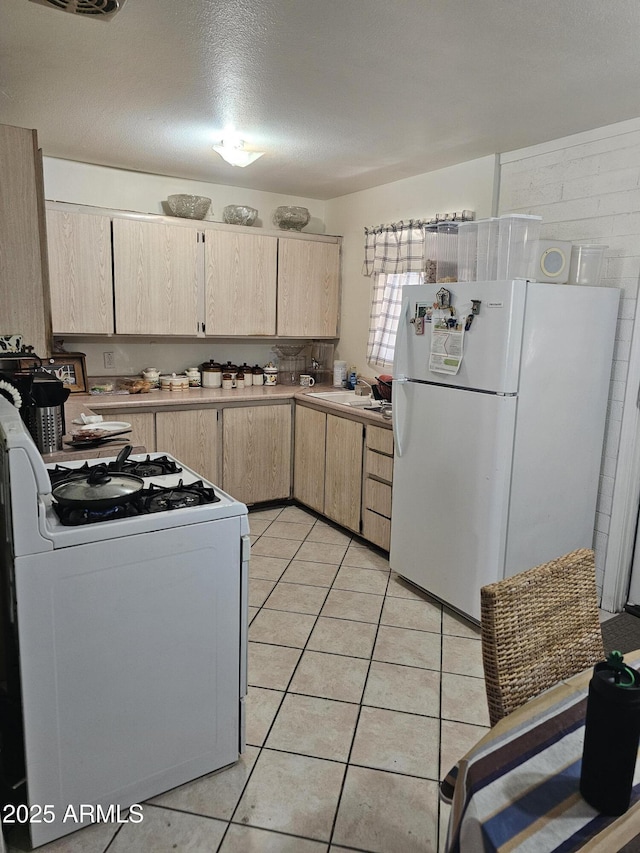 4426 S 36th Dr, Phoenix, AZ 85041 - kitchen with light brown cabinetry, a sink, light countertops, white appliances, and light tile patterned flooring
