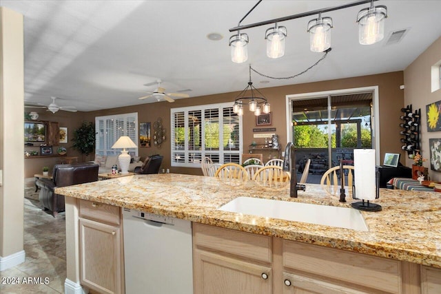 kitchen featuring sink, dishwasher, hanging light fixtures, and a healthy amount of sunlight