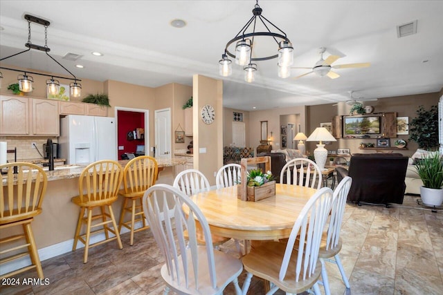 dining area featuring ceiling fan with notable chandelier