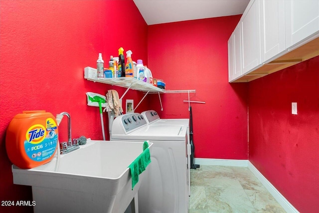 laundry area featuring sink, washer and dryer, and cabinets