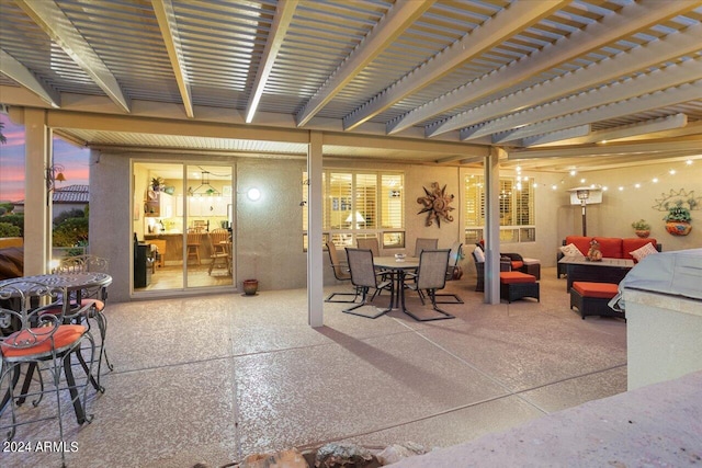 patio terrace at dusk with a pergola and outdoor lounge area