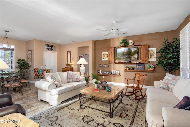 living room with ceiling fan with notable chandelier