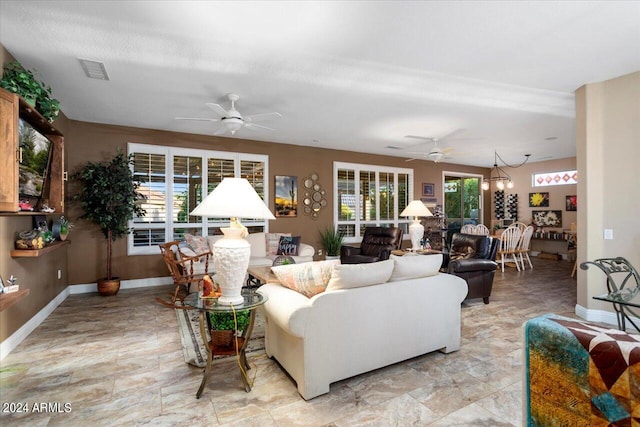 living room featuring a textured ceiling and ceiling fan with notable chandelier