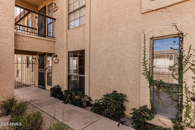 doorway to property featuring a gate and stucco siding