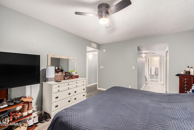 bedroom featuring a ceiling fan, visible vents, light wood-style flooring, and baseboards