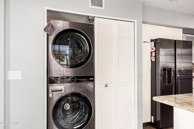 washroom with laundry area, visible vents, and stacked washer and clothes dryer