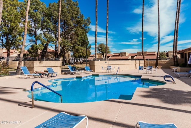 pool with a patio and fence