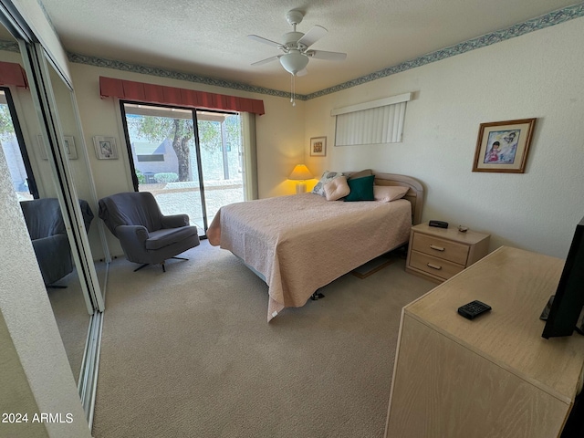 bedroom with a textured ceiling, carpet floors, access to outside, and ceiling fan