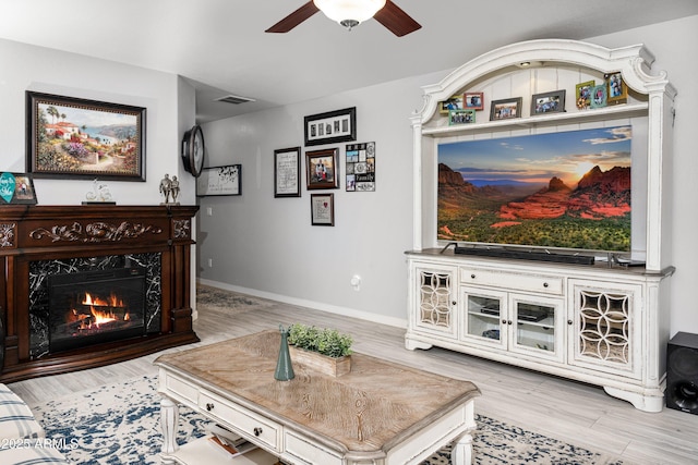 907 E Kelsi Ave, San Tan Valley, AZ 85140 - living room featuring a ceiling fan, a premium fireplace, wood finished floors, and baseboards