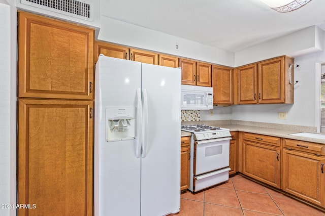 kitchen featuring white appliances, sink, and light tile patterned floors