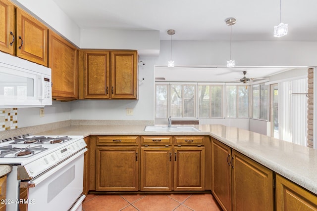 kitchen with white appliances, decorative light fixtures, sink, and light tile patterned floors