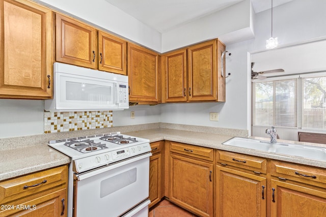 kitchen with pendant lighting, sink, decorative backsplash, ceiling fan, and white appliances