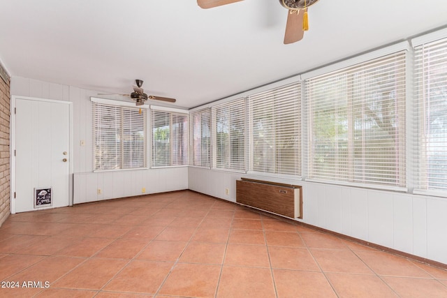 unfurnished sunroom featuring ceiling fan