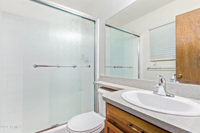 bathroom with walk in shower, vanity, and toilet