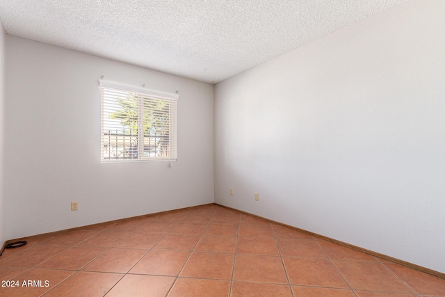 unfurnished room with light tile patterned floors and a textured ceiling