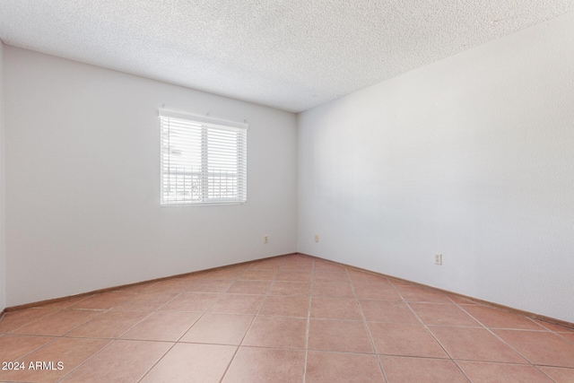 unfurnished room featuring light tile patterned floors and a textured ceiling