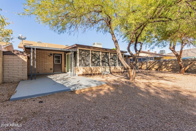 rear view of property with a sunroom and a patio area