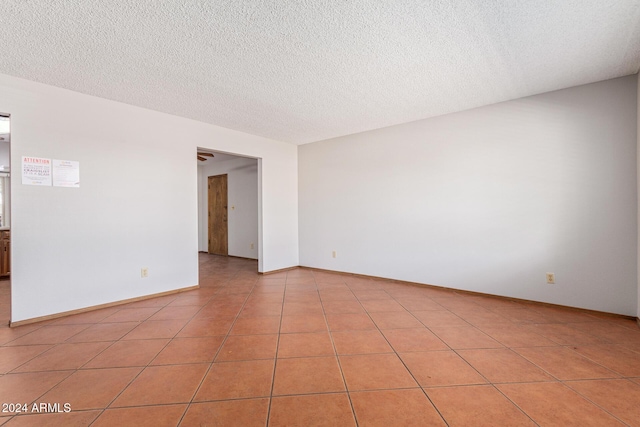 unfurnished room with light tile patterned flooring and a textured ceiling