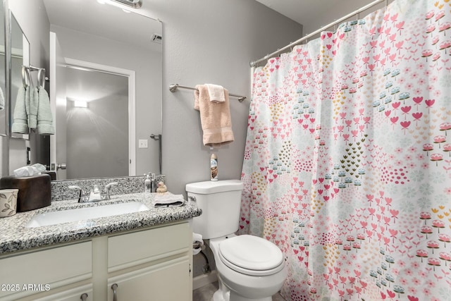 bathroom with vanity, toilet, and walk in shower