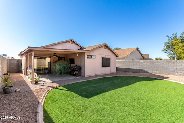 rear view of property with a lawn, ceiling fan, and a patio