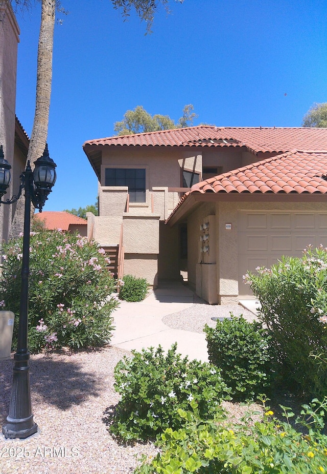 8700 E Mountain View Rd Unit 2029, Scottsdale, AZ 85258 - mediterranean / spanish home with stucco siding, a tiled roof, and a garage