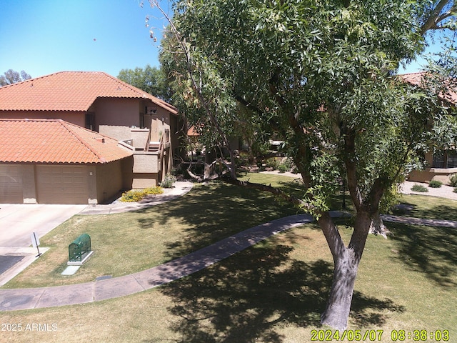 8700 E Mountain View Rd Unit 2029, Scottsdale, AZ 85258 - view of property exterior with a tile roof, stucco siding, an attached garage, a yard, and concrete driveway