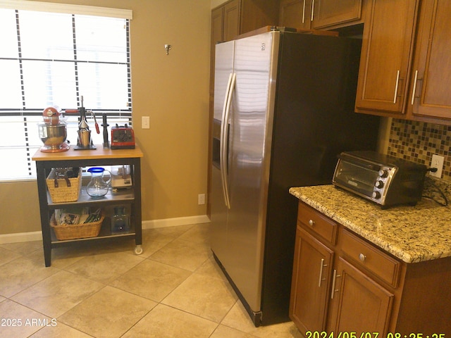 8700 E Mountain View Rd Unit 2029, Scottsdale, AZ 85258 - kitchen with brown cabinets, baseboards, light tile patterned floors, and backsplash