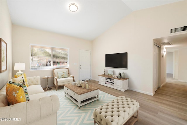 living room with light hardwood / wood-style floors and vaulted ceiling