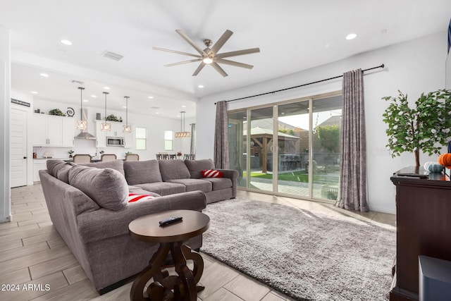 living room with ceiling fan and light hardwood / wood-style flooring