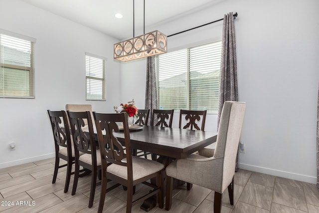 dining space with light hardwood / wood-style flooring and a notable chandelier