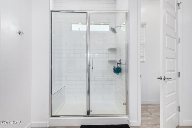 bathroom featuring a shower with door