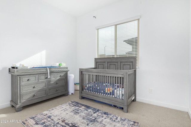 bedroom with light colored carpet and a crib