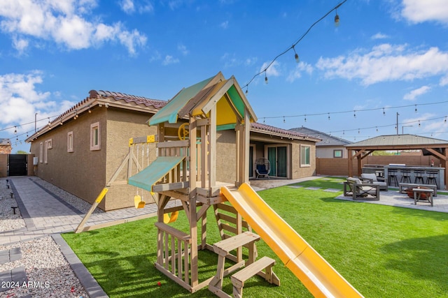 view of jungle gym with a gazebo, a patio area, a yard, and an outdoor fire pit