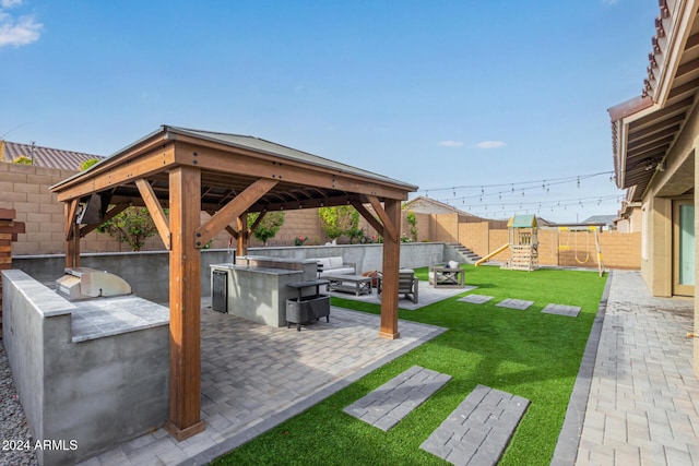 view of yard featuring area for grilling, an outdoor living space with a fire pit, a gazebo, a patio area, and a playground