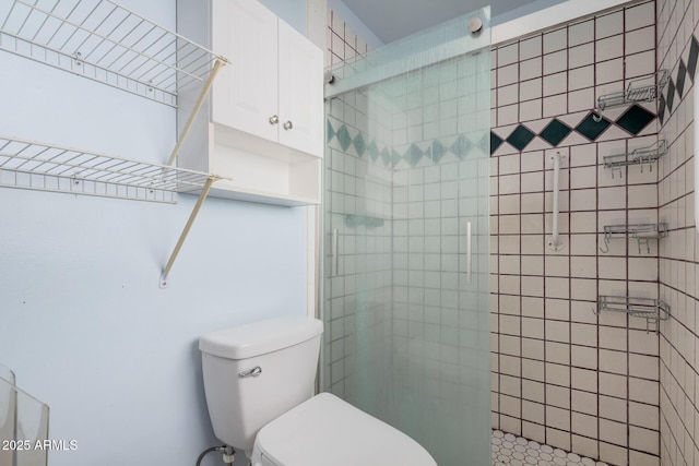 bathroom featuring a tile shower and toilet