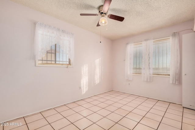 tiled spare room with a textured ceiling and ceiling fan