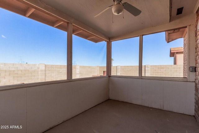 unfurnished sunroom with ceiling fan