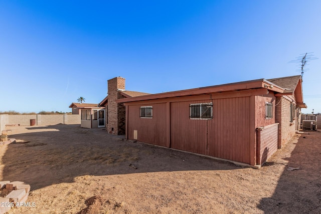 rear view of property with central AC