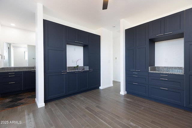 2943 E Lookout Ln, Overgaard, AZ 85933 - kitchen with dark wood-style floors, stone counters, ceiling fan, baseboards, and blue cabinetry