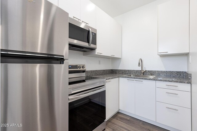 2943 E Lookout Ln, Overgaard, AZ 85933 - kitchen featuring stainless steel appliances, a sink, white cabinetry, wood finished floors, and modern cabinets