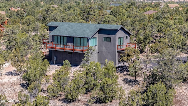 2943 E Lookout Ln, Overgaard, AZ 85933 - view of front of home featuring a deck, roof with shingles, and a wooded view