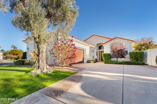 mediterranean / spanish home featuring a garage and a front yard