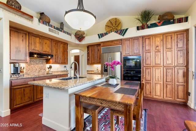 kitchen featuring sink, pendant lighting, lofted ceiling, a kitchen island with sink, and black appliances