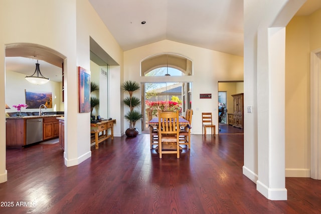 dining area with dark hardwood / wood-style floors, vaulted ceiling, and sink